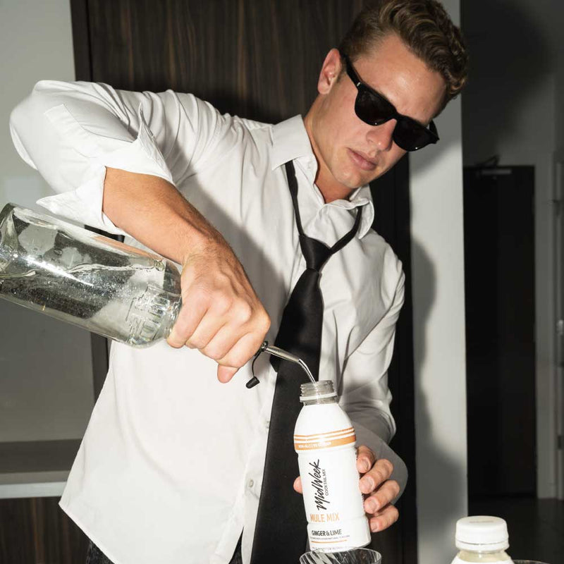 Man pouring liquor into a Midweek Mixer bottle.