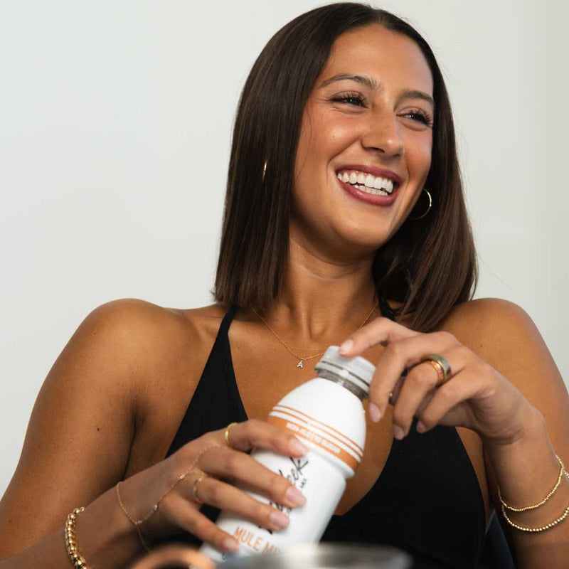 Woman holding a Midweek Mixer bottle