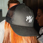 Black cap with white MIdweek logo worn backwards